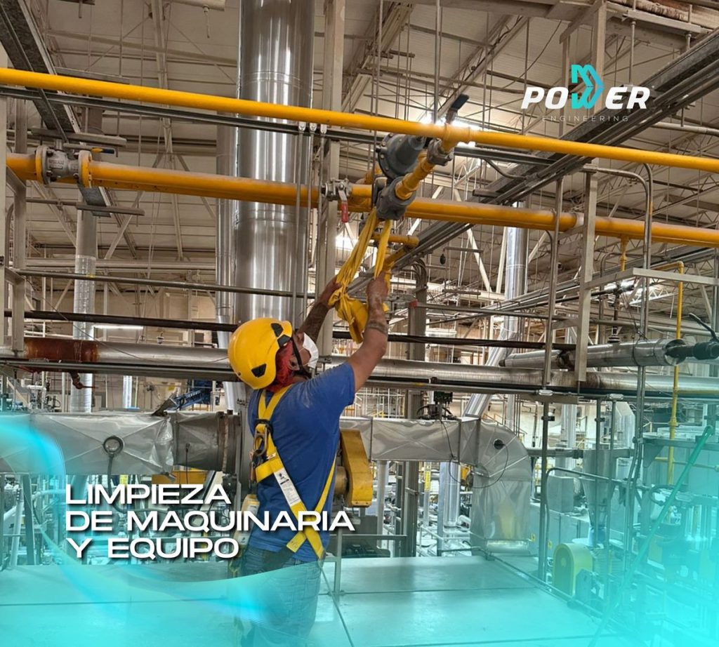 Técnico limpiando tuberías y maquinaria industrial para mantenimiento preventivo